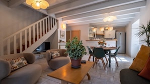 Una sala de estar moderna con una escalera, un comedor y una cocina.