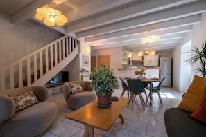 Ein modernes Wohnzimmer mit Treppe, Essbereich und Küche.