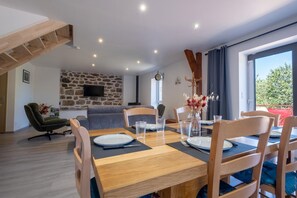 A dining area with a wooden table set for four, surrounded by chairs. - Gîte La Sagnette 4/6 persons (LANUEJOLS)