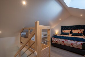A bedroom with a bunk bed, a skylight, and a bedside table with a lamp. - La Sagnette Vacation Rental for 4–6 People (LANUEJOLS)