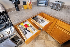 A kitchen with a stove, toaster, and drawer with kitchen utensils. - 3-bedroom house in lovely Frisco with Pool and hot tub! (Frisco)