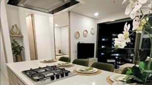 A modern kitchen with a gas stove, a large island, and a dining area with chairs. - Zen Oceanview Apartment Reserva del Mar 2, Santa Marta, Colombia (Gaira)
