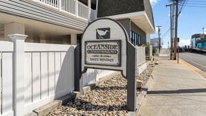Señal para Oceanside Condominiums, con logotipo de ave, que indica ventas y alquileres.