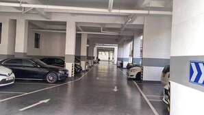 Uma garagem de estacionamento com vários níveis e carros estacionados em vagas designadas.