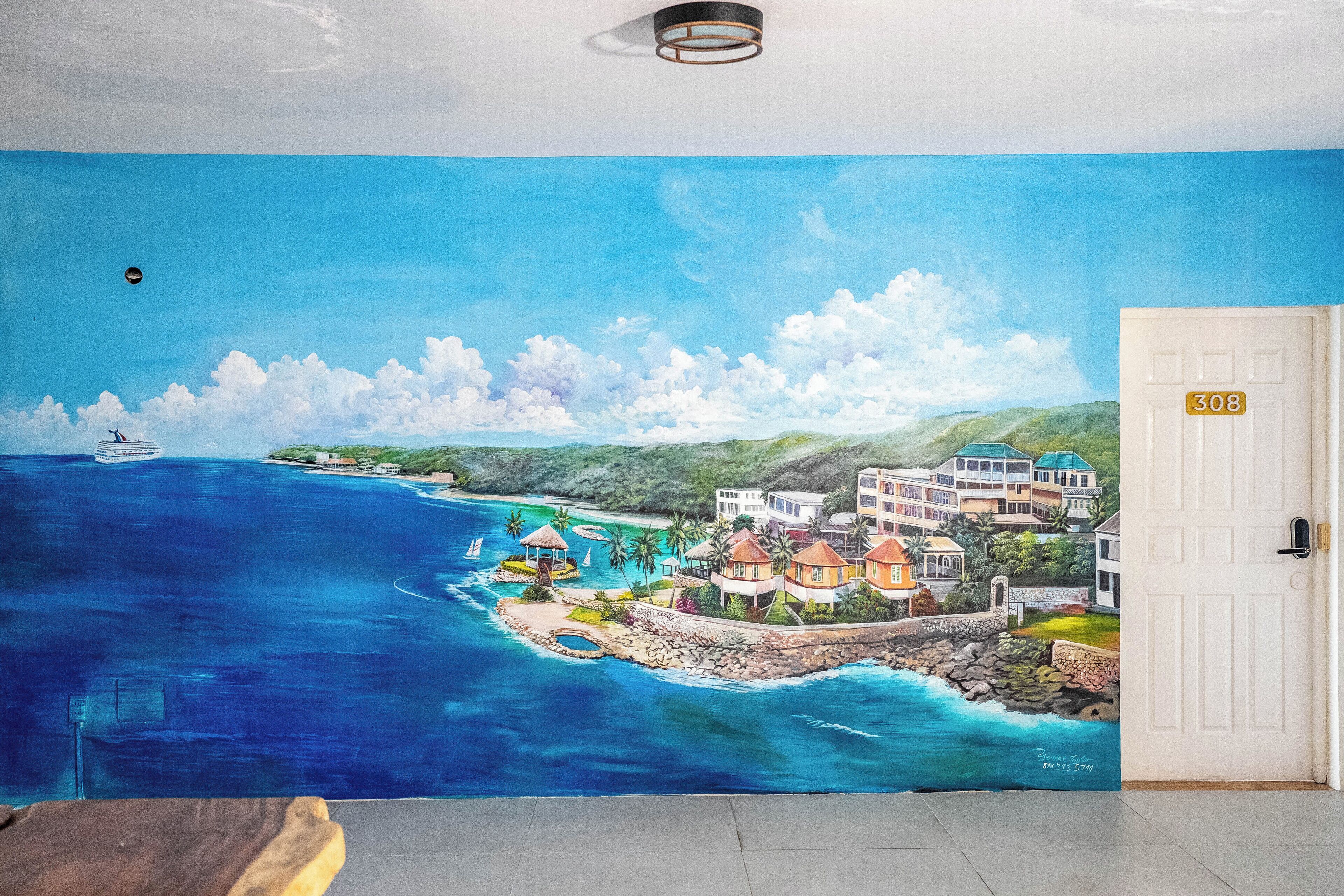 Um mural retratando uma cena costeira com edifícios, um cais e um barco.