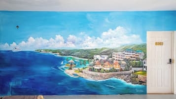 Um mural retratando uma cena costeira com edifícios, um cais e um barco.