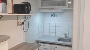 Cocina compacta equipada con microondas, lavavajillas Bosch y un lavamanos.