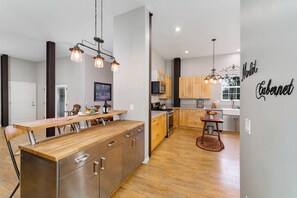 Eine moderne Küche mit Holzschränken, Edelstahlgeräten und Pendelleuchten.
