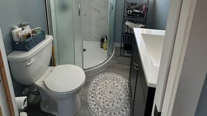 Un baño con inodoro, ducha y lavamanos.
