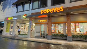 A Popeyes restaurant with a visible outdoor seating area and a sign for KUIYAJ restaurant adjacent to it. - Spectacular 2.5BR Connected to Eastwood  Mall (Quezon City)