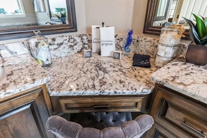 A marble countertop with a vanity mirror, a decorative seahorse, and a candle holder. - The Regent Abilene Luxury Retreat w Patio Fire (Abilene)