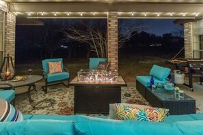 Un espacio al aire libre con mobiliario, una chimenea y una parrilla.