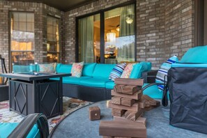 A brick exterior wall, a teal sofa with patterned cushions, and a stack of wooden blocks.
