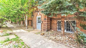 A brick building with a blue door, a stone pathway, and a tree in front. - Hidden Gem in the Heart of Capitol Hill (Denver)