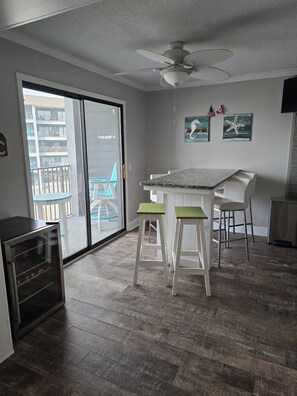A kitchen with a dining area, a ceiling fan, and a view of a balcony. - A308 at the Myrtle Beach Resort
Beautiful Oceanfront 2 bdrm condo. (Myrtle Beach)