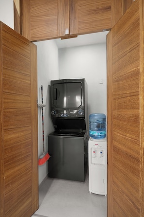 Une petite cuisine équipée d’un four à micro-ondes, d’un petit réfrigérateur et d’un distributeur d’eau.