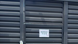 A metal gate with a sign indicating 'Apartment #1 & #2.' - Walk Everywhere , Budget Stay w/ AC + WiFi #1 (La Fortuna)