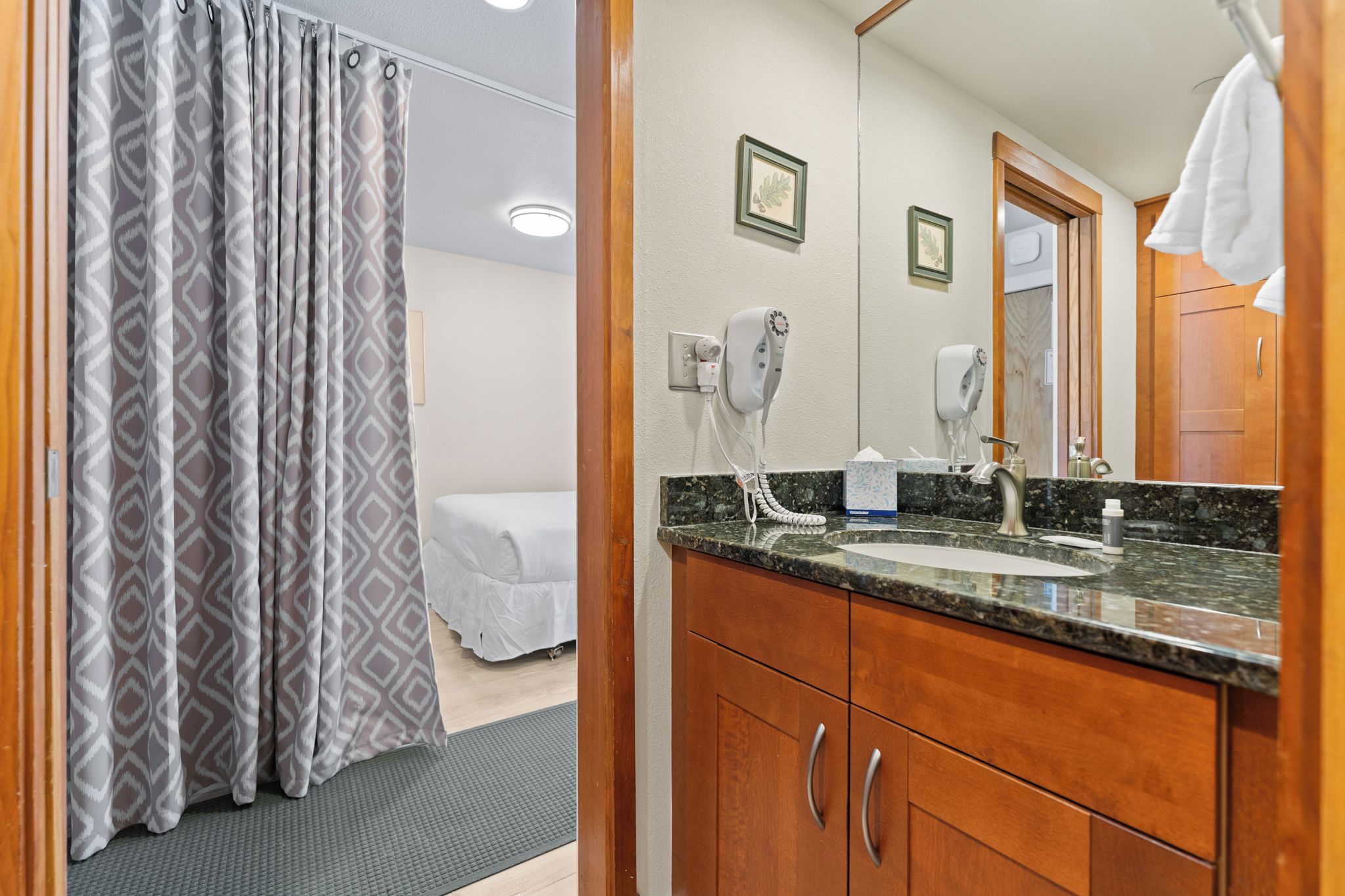 A bathroom with a sink, mirror, towel rack, and a shower curtain.