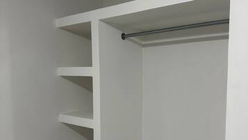 A white closet with multiple shelves and two metal rods.