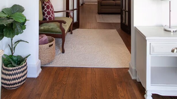 An interior view of a home with a wooden floor, a sofa, a dining table, and a kitchen area visible through an open doorway. - Prime football location- condo walking distance from stadium (Knoxville)