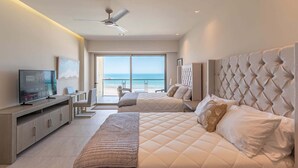 A modern hotel room with a large bed, a desk, a television, and a view of the ocean. - Sonoran Star 1-0805-3Bed (Puerto Peñasco)