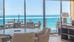 A room with a large window overlooking the ocean, a round table, and several chairs. - Sonoran Star 1-0805-3Bed (Puerto Peñasco)
