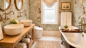 Ein Badezimmer mit zwei Waschbecken, einer Badewanne, einer Kristalllüster und einem gemusterten Teppich.
