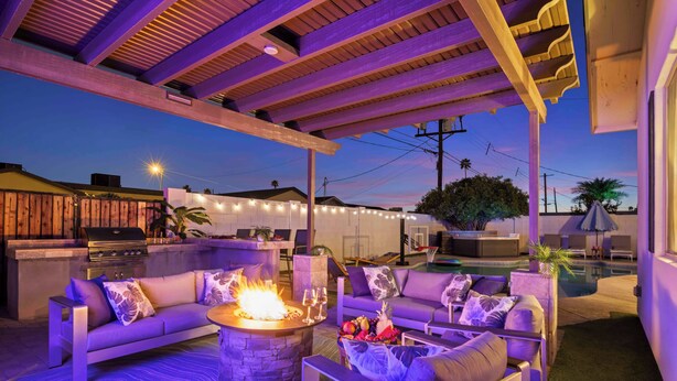 An outdoor patio with a fire pit, sofas, and a pool area. - Scottsdale-4BR Retreat-Pool, Fire Pit, Pool Table, Shuffle board, BBQ (Scottsdale)