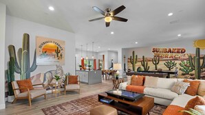 A spacious living room with a sofa, armchairs, a coffee table, and a cactus wall art. - Scottsdale-4BR Retreat-Pool, Fire Pit, Pool Table, Shuffle board, BBQ (Scottsdale)