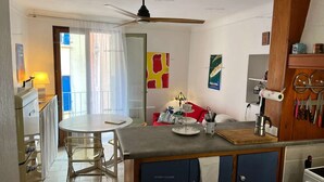 Una cocina moderna con comedor, ventilador de techo y vistas al exterior.