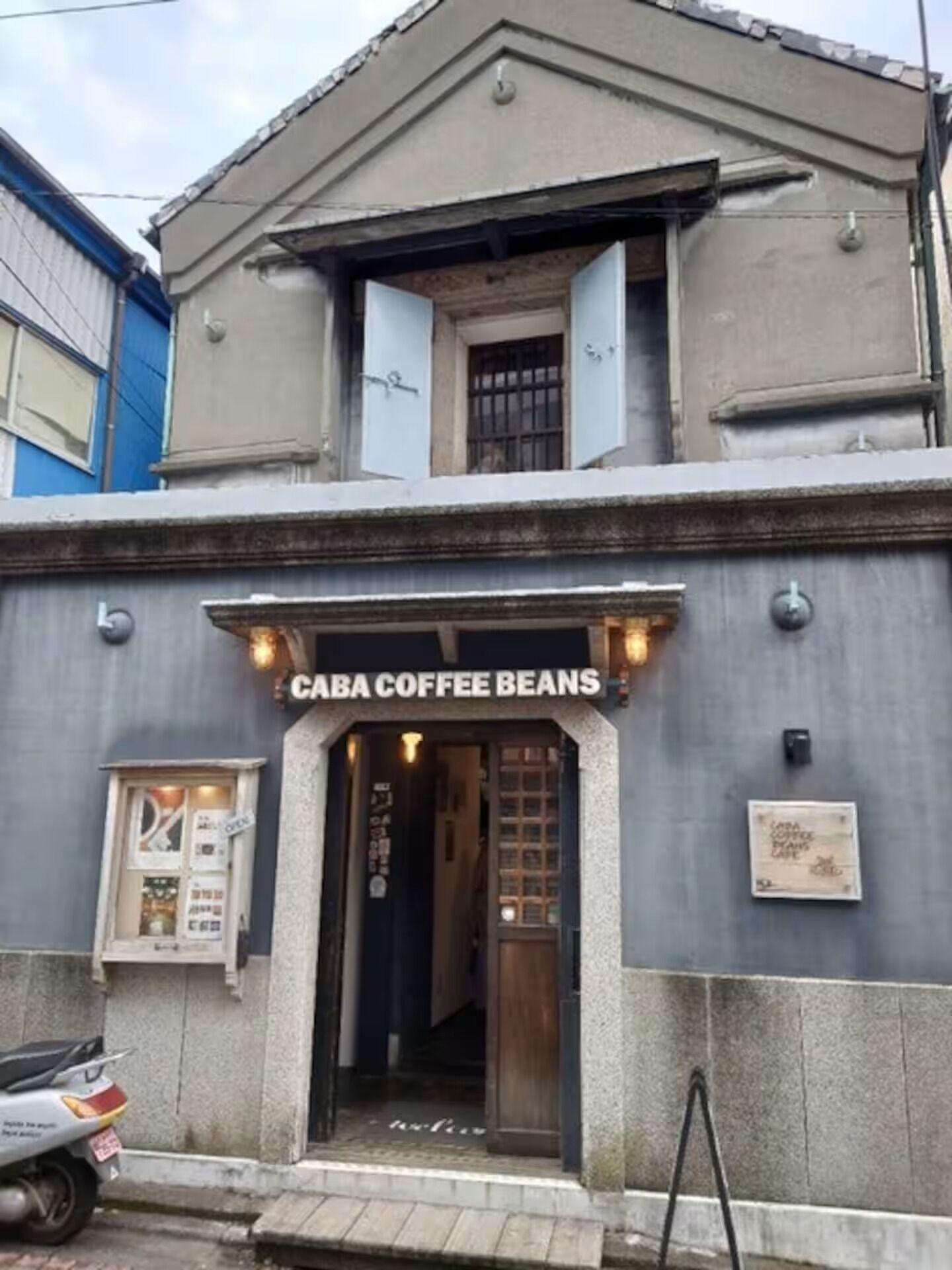 Un bâtiment dont l’entrée est marquée par une enseigne indiquant « CABA COFFEE BEANS ».