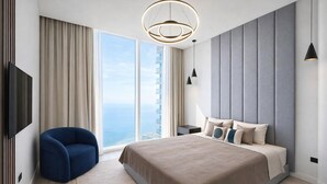 A modern bedroom with a large bed, a blue chair, a TV, and a view of the ocean. - Exclusive Palm View Penthouse, Terrace & Pool (Dubai)