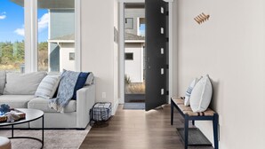 A modern living room with a sofa, a coffee table, and a bench. - Oceanview Retreat - Hot Tub + Game Garage + Spa Suite + Kids Cave - Westport, WA (Westport)