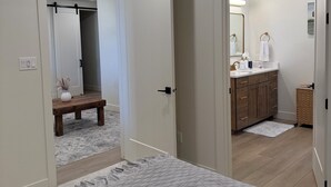 A bedroom with a bed, a bedside table, a mirror, and a wardrobe. - Cozy Casita with Mountain Views (Cedar City)