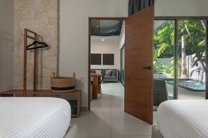 A hotel room with a bed, a wooden bench, a hanging rack, and a view of a pool and outdoor area. - Esperia: Sophisticated 6BR Oasis with Pool (Tulum)