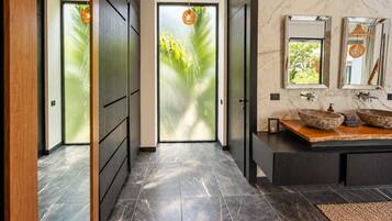 Un bagno moderno con un grande specchio, due lavabi a incasso e un mobile bagno in legno.