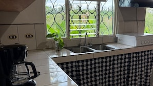Eine Küche mit Fenster, einer Kaffeemaschine und einem Spülbecken.