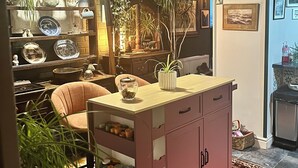 Ein gemütliches Wohnzimmer mit einem Holzkabinett, einem Esstisch und verschiedenen Dekorationselementen.