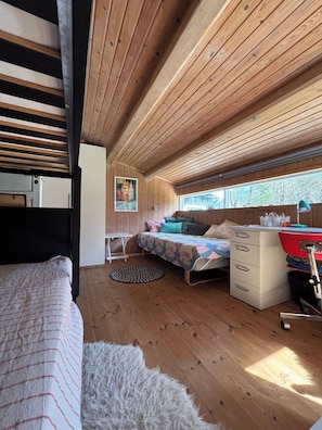 A cozy room with a bed, a desk, a dresser, and a window with a view. - Bright summer house only 300 m from the water (Sjællands Odde)