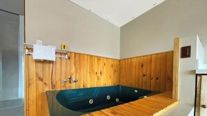 Un bagno moderno con parete rivestita in legno, una vasca freestanding e un appendi-asciugamani.