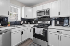 A modern kitchen with white cabinets, a stainless steel stove, a microwave, and a dishwasher. - 4 Min Drive Downtown - 7 Min Walk to Golden Belt (Durham)