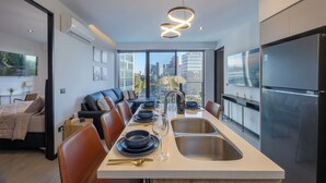 A modern kitchen with a dining area, large windows, and a city view. - Elegant Modern Pool Gym Point Sâo Paulo-Andares (Guadalajara)