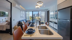 A modern kitchen with a dining area, large windows, and a city view. - Elegant Modern Pool Gym Point Sâo Paulo-Andares (Guadalajara)