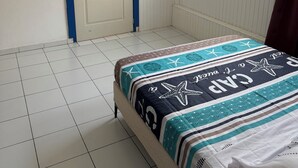 A room with a bed, a door, a window, and an air conditioning unit. - Residence with sea view and close to beaches (Le Marin)