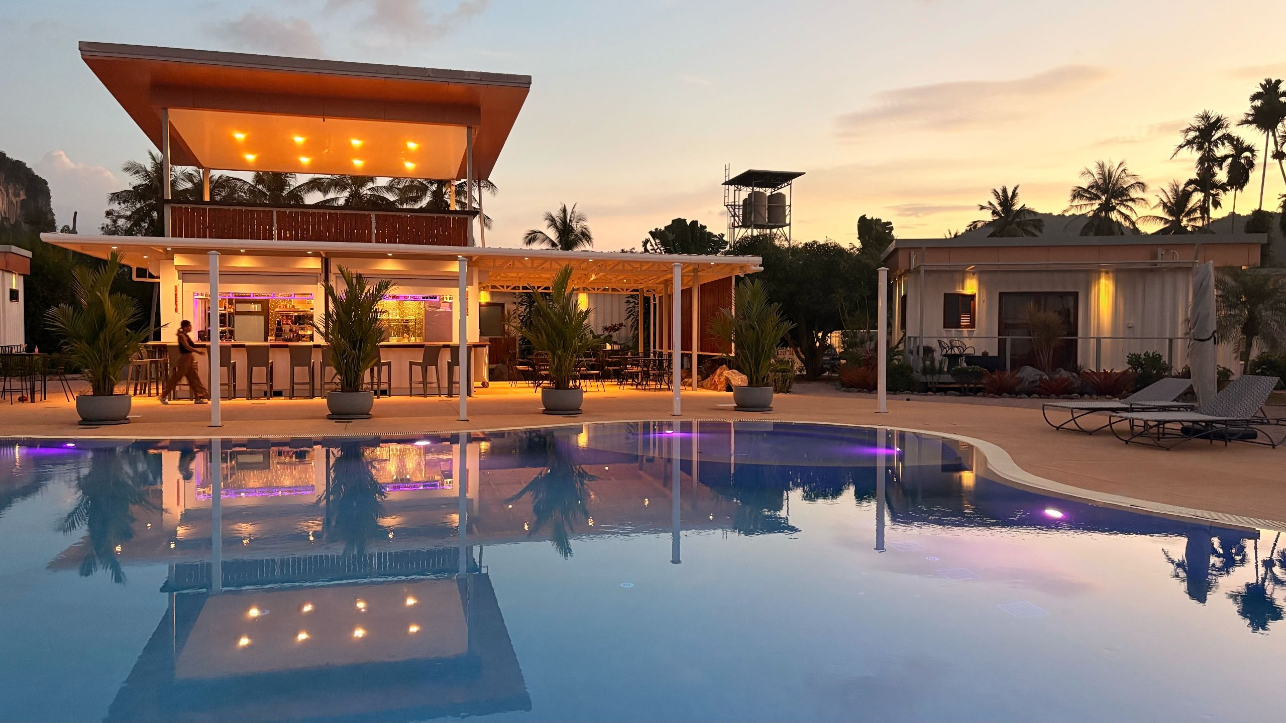 Un resort con piscina, bar al aire libre y zona de descanso.