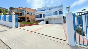 Una casa moderna a due piani con garage, prato curato e cancello in metallo blu.