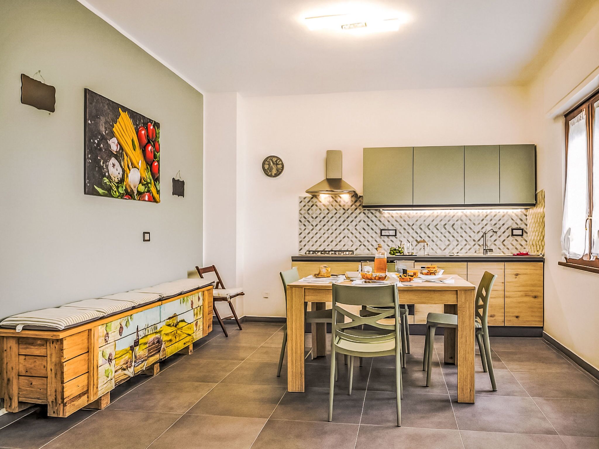 Une cuisine moderne avec un coin repas, des meubles en bois et une horloge murale.