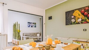 Uma área de refeições com uma mesa posta para o café da manhã, incluindo croissants, suco e café.