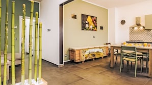 Uma cozinha moderna com área de jantar, apresentando uma mesa e cadeiras de madeira, uma ilha de cozinha e um quadro fixado na parede.