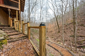 A wooden staircase leading to a building with a covered entrance, surrounded by a forested area. - NEW Kink Cabin w/ Private Creek (Sevierville)